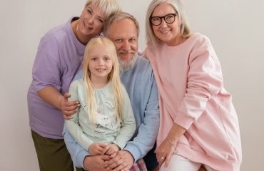 A happy multigenerational family posing indoors with smiles and affection.